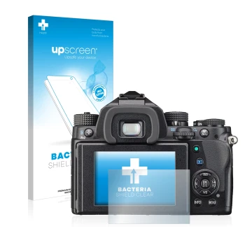 Parte frontal de un envase de producto con el logotipo de la marca upscreen. Al lado se muestra el dispositivo Pentax KP con s